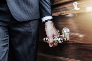 Man in suit holding casket handle