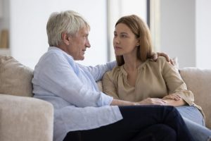 Father and daughter sitting together and talking quietly