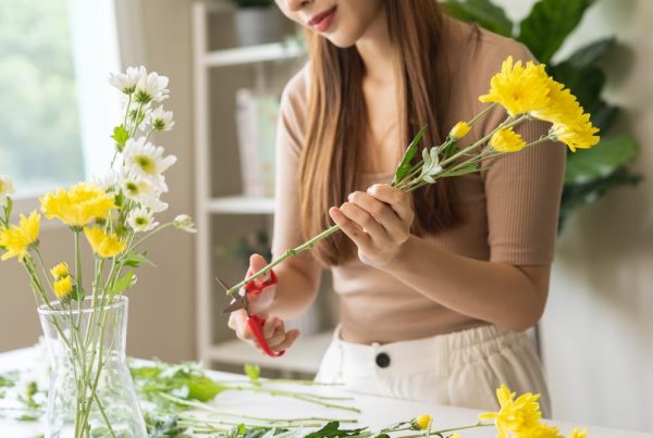 Woman cutting flowers to create a flower arrangement