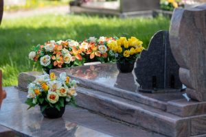 Marble-top grave with yellow flowers left by mourners