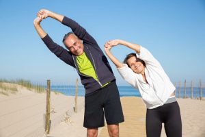 Man and woman stretching at the beach