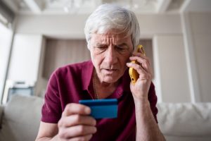 Concerned senior adult man on phone with credit card company
