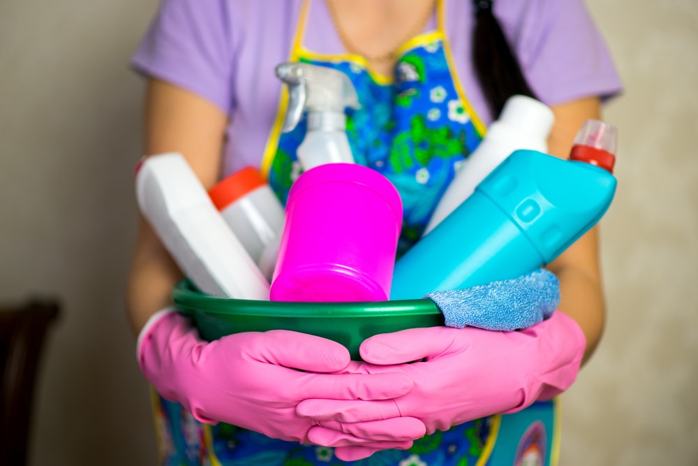 Creative sympathy gifts: woman holding bucket of cleaning supplies to help with household chores