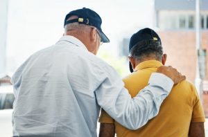 Two elderly male friends walking and talking together