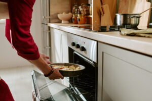 Woman putting casserole in oven to help a grieving friend