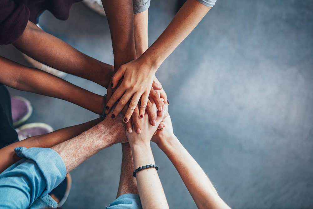 Hands together in a circle in solidarity