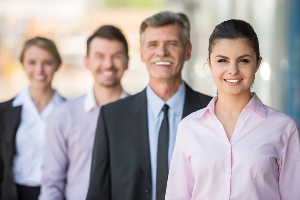 Four professionals lined up, smiling