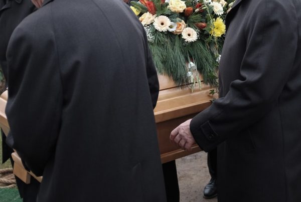 Pallbearers lowering casket into grave