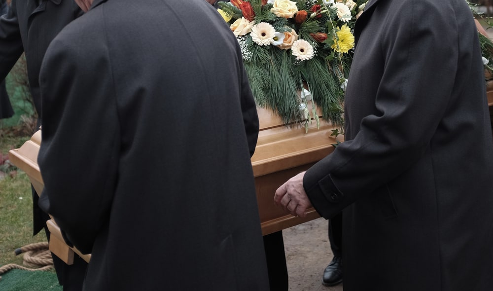 Pallbearers lowering casket into grave