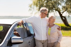 Older couple standing next to car looking lovingly at each other