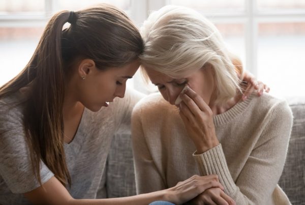 Mature woman and adult daughter sad together