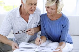 Man wearing white shirt and woman wearing blue shirt reviewing contract