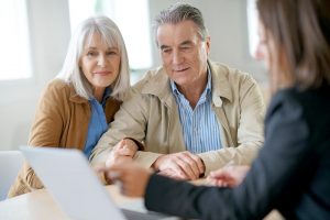 Older man and woman reviewing paperwork with professional