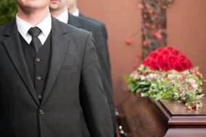 Three men on left side of casket, carrying it