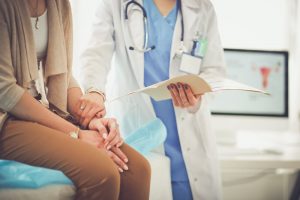 Woman talking with female doctor at exam