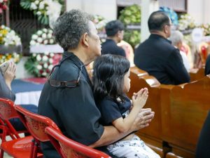 Grandmother holding granddaughter in her lap at a funeral