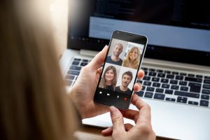 Woman holding smart phone in hand, on video call