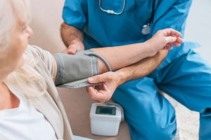 Shows nurse taking patient's blood pressure