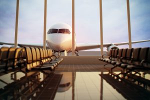 Shows airport terminal with airplane outside window