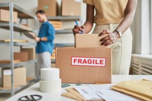 Shows man and woman packing boxes carefully