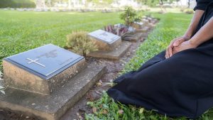 Shows woman visiting a cemetery where there are monument regulations