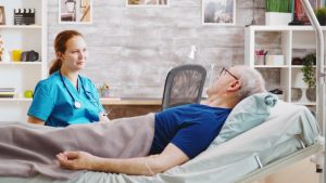 Shows man receiving care at home from a hospice nurse