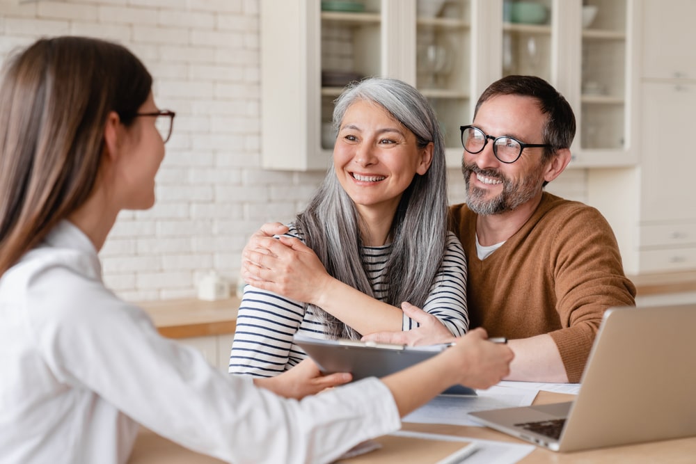 Shows couple talking to funeral professional about their funeral plans