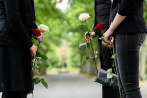 Shows a family of four with flowers honoring a loved one