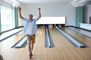 Shows man participating in a relaxing activity like bowling
