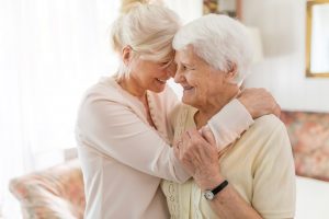 senior woman hugging her elderly mother