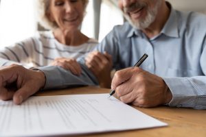 Older man and woman signing documents