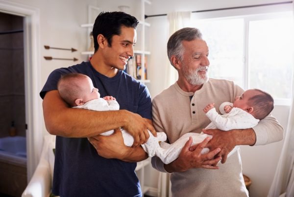 Father and adult son, holding son's newborn twins