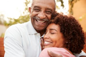 Man smiling and hugging adult daughter