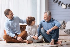 Father, son, and grandson sitting on floor enjoying time together