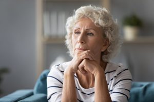 Woman sitting on couch thinking deeply