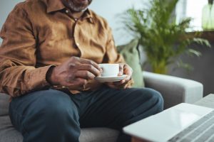 Man sitting on couch with cup of tea