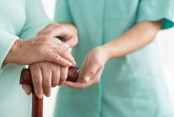 Nurse holding patient's hand in a caring way