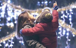mother holding son looking at Christmas lights