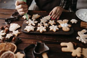 person icing snowflake and gingerbread man cookies