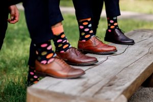 Four men wearing matching polka dot socks