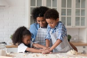 woman baking with two children