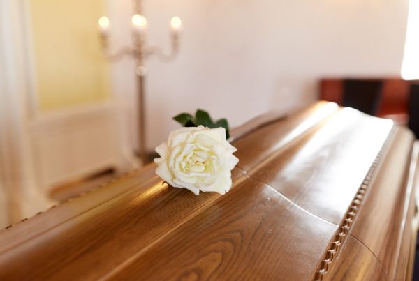 Cover of a casket with a white rose laid on top