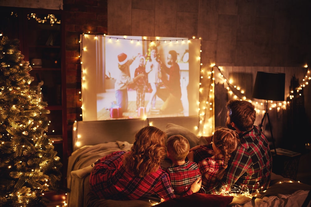 family watching a Christmas movie together with lights
