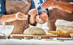 Father and adult daughter making homemade bread together