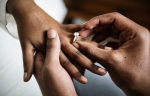 African American man putting a ring on a woman's finger