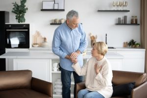 Husband checking on wife as she holds a hand to her chest