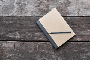 blank notebook with pencil on wooden table, business concept