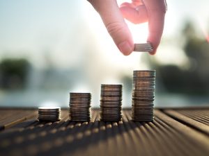 hand stacking quarters in stacks that increase in height