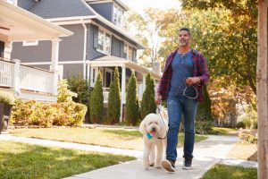 Man walking his dog around the neighborhood, getting outside