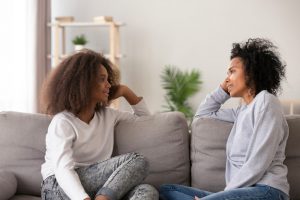 Mother and daughter sitting on couch, sharing memories